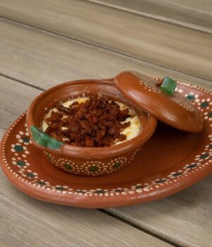 Appetizing queso fundido with chorizo served in a traditional Mexican clay dish.
